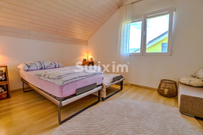 Chambre confortable avec vue lumineuse et décoration chaleureuse.