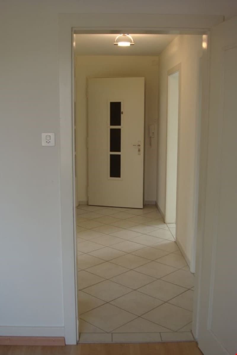 white doors, tiled flooring, hallway light, power outlet