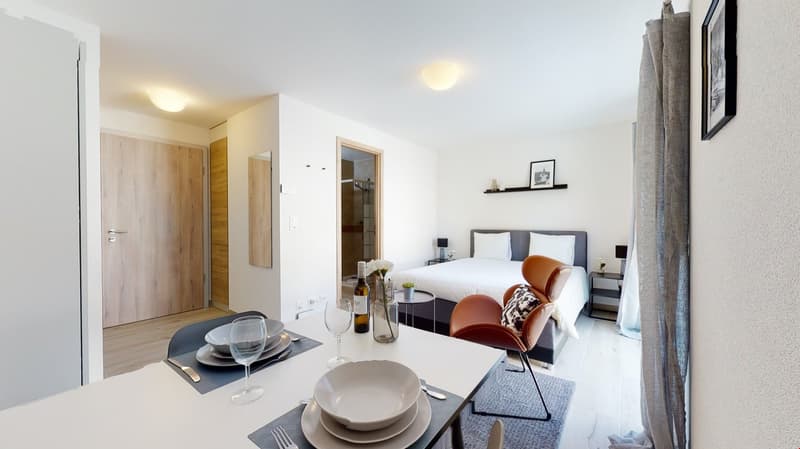 dining area, modern decor, table, 4 chairs, wine bottle, vase with flowers, round bedside table, lamps, bed with pillows, shelf with frames, wooden floors
