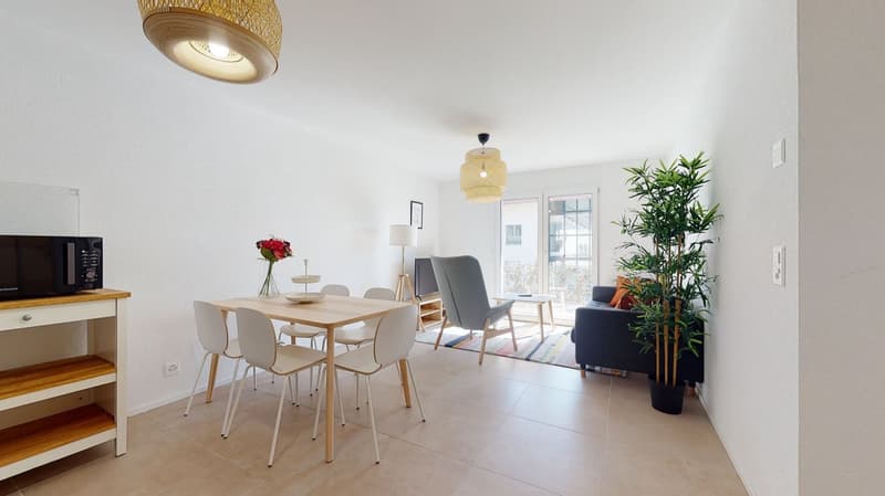 Dining room with a dining table and chairs, a couch, a microwave, and a potted plant.