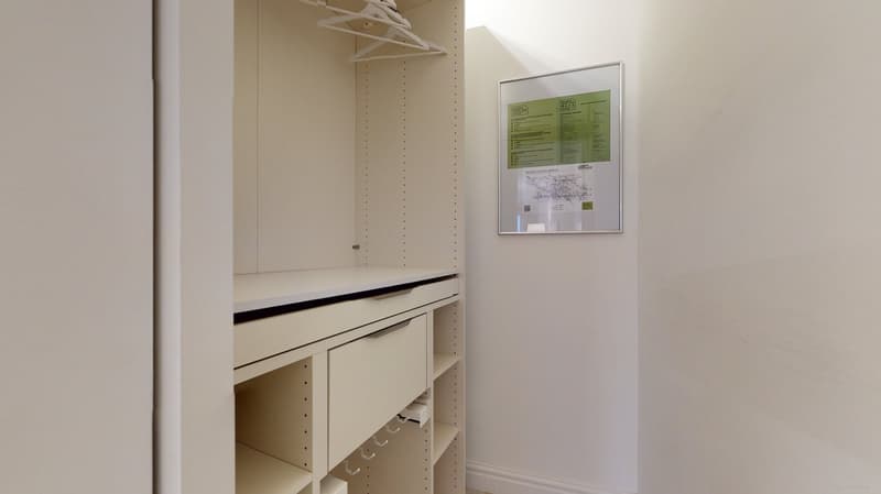 Spacious closet with multiple drawers, shelves, and a clothes hanger.