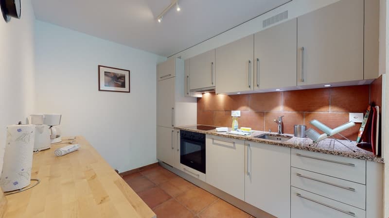 modern white kitchen, granite counter, black oven, sink, dishwasher, cabinet, paper towels, microwave, power outlet