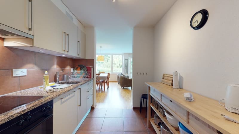 kitchen, gas stove, sink, white cabinets, countertop, table, chairs, dining room, clock, basket, paper towel