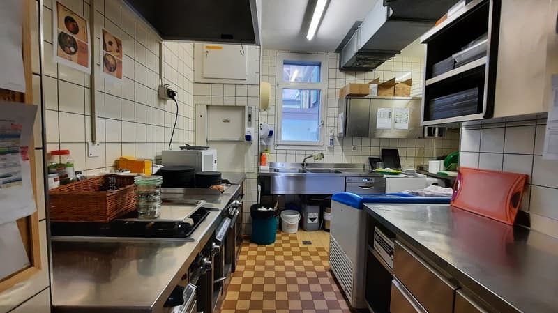stainless steel countertops, electric stove, oven, microwave, sinks, baskets, garbage bins, windows, tiled floor, open shelves, paper towel dispenser, cabinet