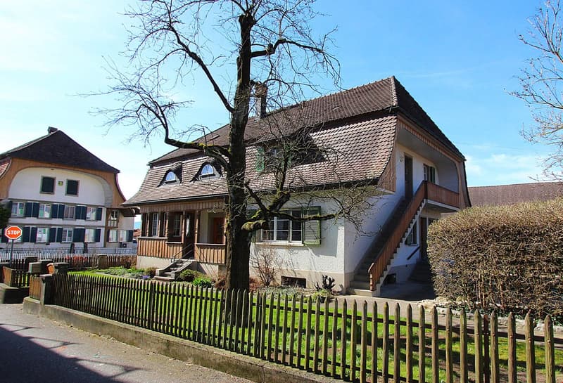 2 story house, brown roof, white walls, wooden fence, tree, stairs, windows