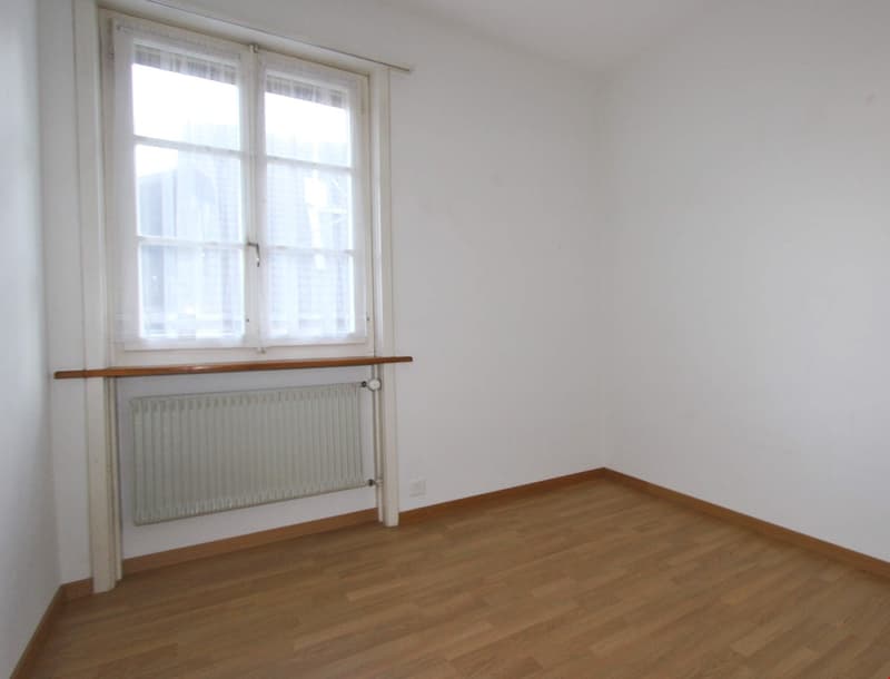 empty room, white walls, wooden floor, window, radiator