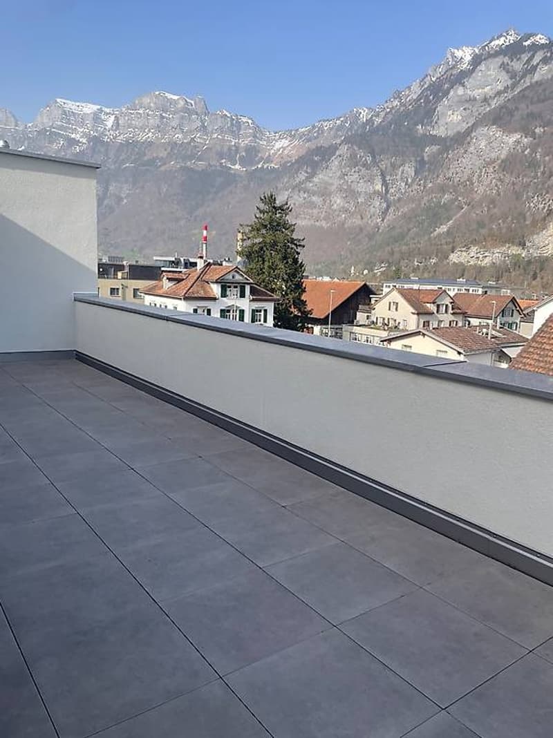 Empty terrace with mountain views and houses in the background