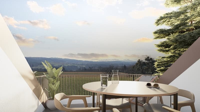 Outdoor balcony with a table, chairs, and a view of a green field and mountains.