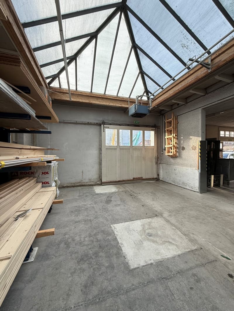 glass roof, white doors, shelves with wooden planks, and boxes, clean concrete floor