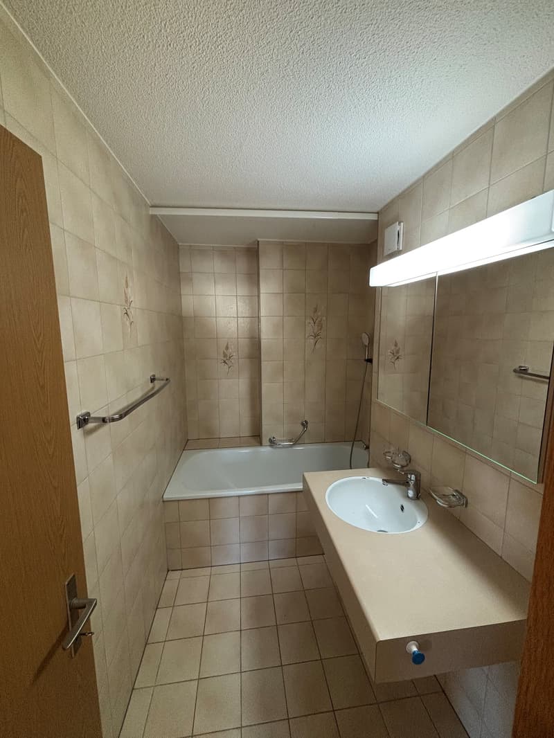 tiled floor, bathtub, sink, mirror, overhead light