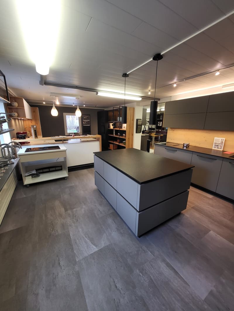 Central kitchen island, grey cabinetry, countertops, kitchen appliances, open shelving, ceiling lamps, flooring
