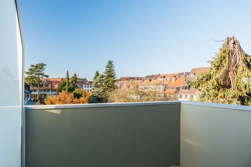 modern balcony with a view of the cityscape, trees and sky