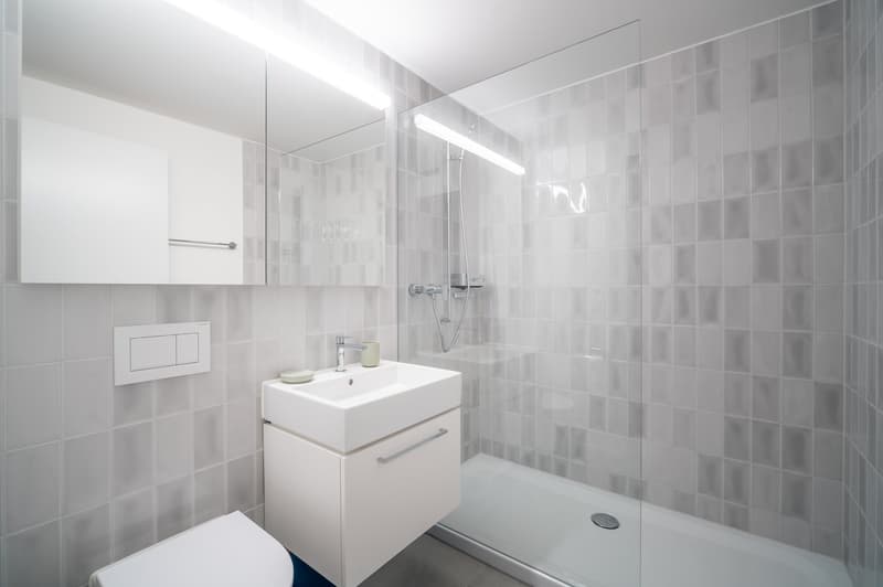 Minimalist white bathroom with sink, shower, and white tile