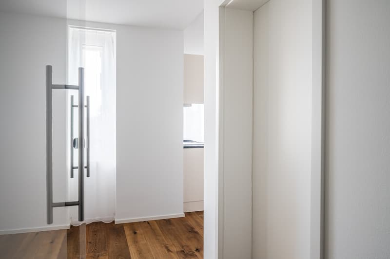 white walls, wooden floor, glass door, white curtains, open door