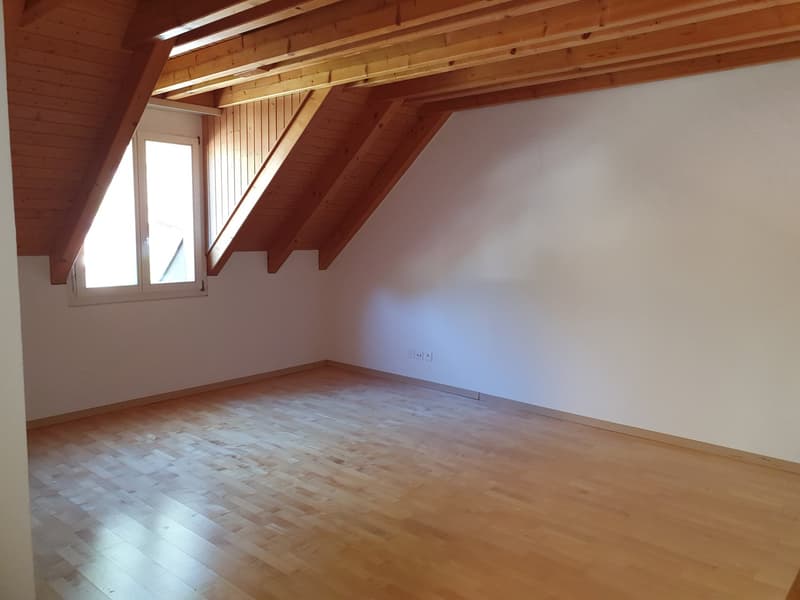 Empty room with wooden ceiling, wooden floor, window, wall outlets