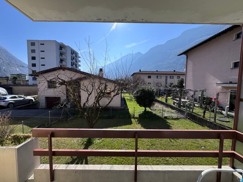 House with balcony, mountain view, car parked in front, fenced yard, trees, and plants