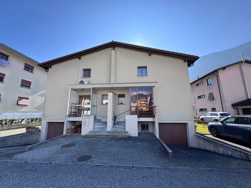 2 story house, beige exterior, brown roof, 2 garages, stairs leading to the entrance, glass windows, air conditioner