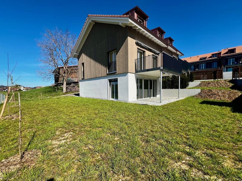 modern house, brown and white exterior, large windows, balcony, raised ground floor, green lawn