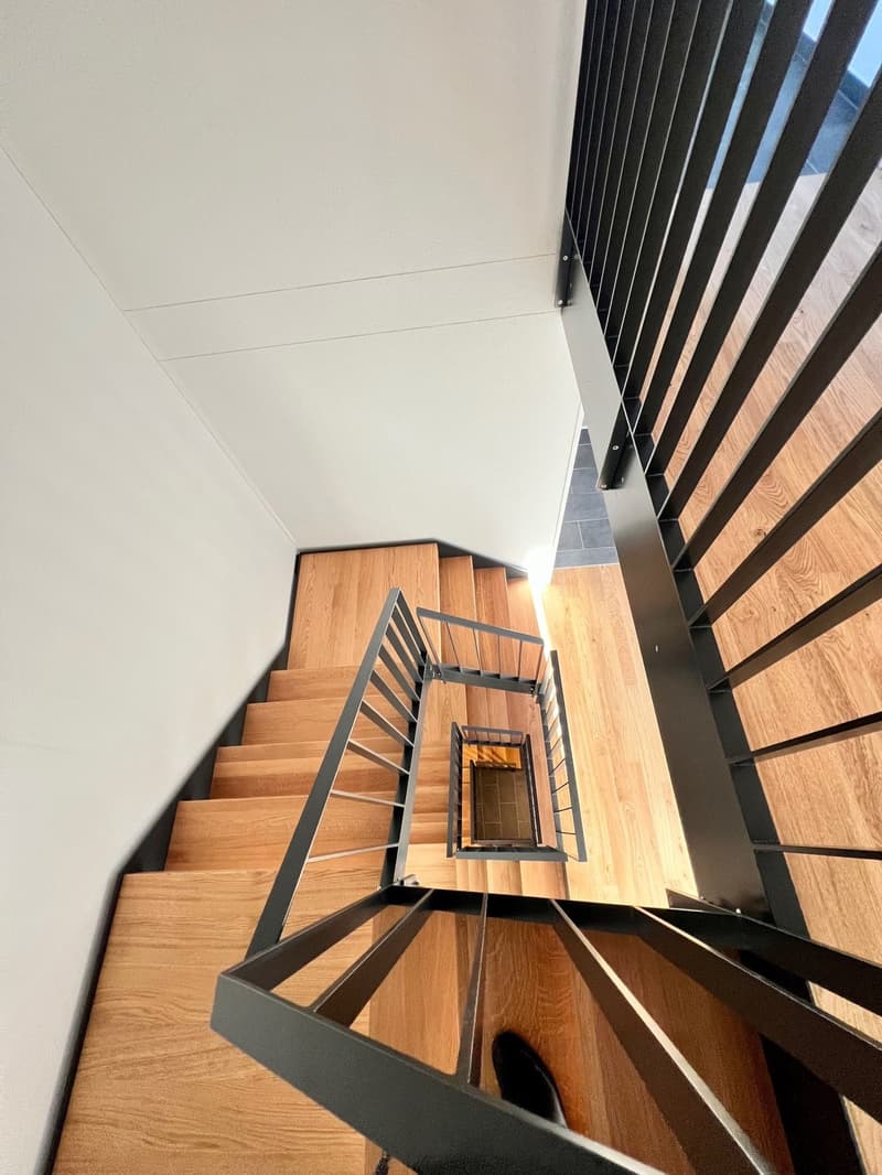 Contemporary staircase with wooden steps and metal railings