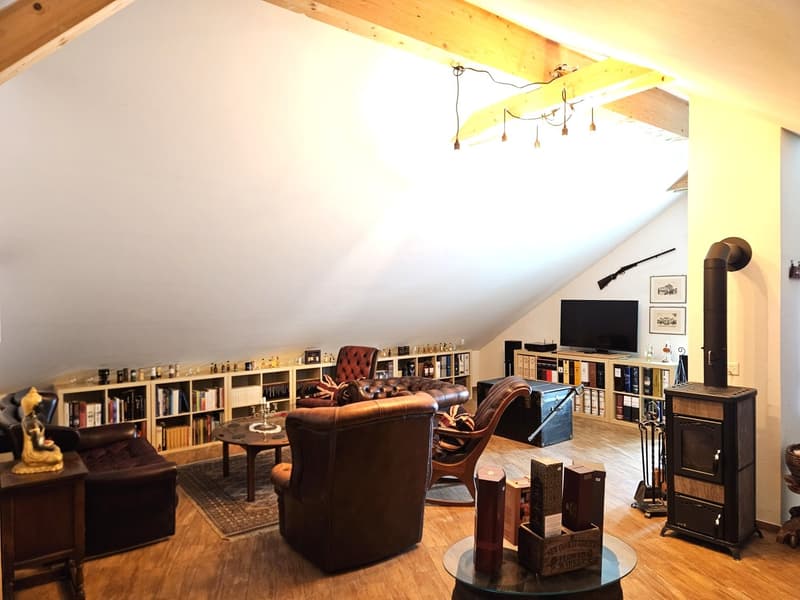 wooden floor, wooden ceiling, fireplace, bookshelves, leather chairs, coffee table, TV, rug, wooden desk, Buddha statue