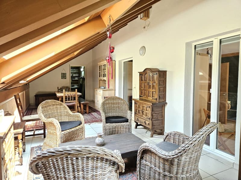 attic room with wooden ceiling, wicker chairs, wooden table, wooden cabinets, glass door, rug