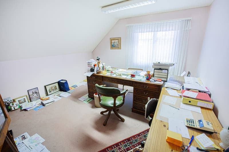 office room with desk, chair, papers, books, picture frame, carpet, window with curtains