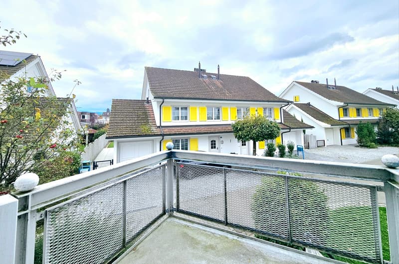 Building complex, yellow shutters, white walls, brown roofs, garage, driveway, balcony