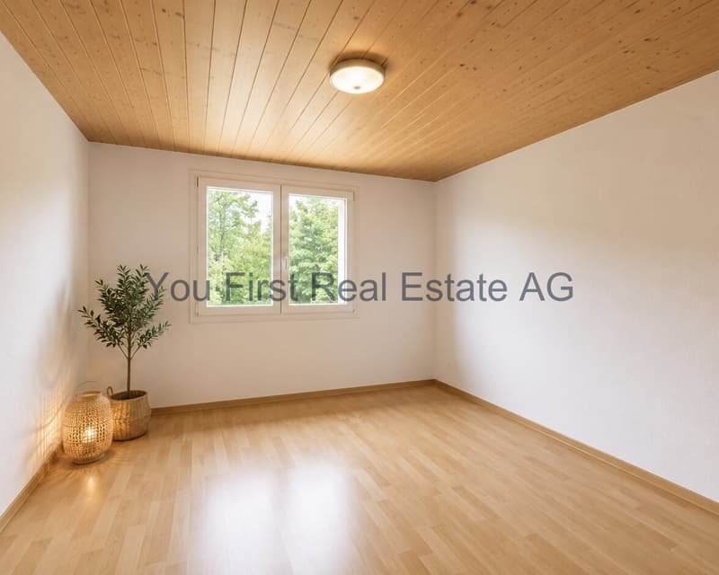 Helles Zimmer mit Holzdecke und großflächigen Fenstern