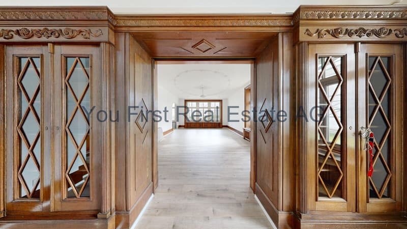 Repräsentativer Flur mit aufwendig gestalteten Holzschrankelementen und eleganter Raumachse