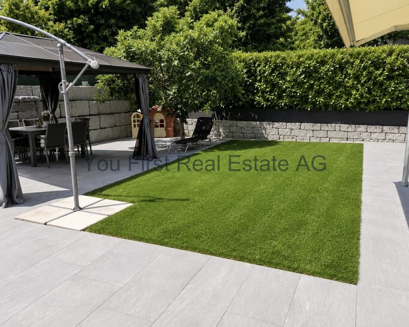 Privater Gartenbereich mit Natursteinmauern und Rasenfläche