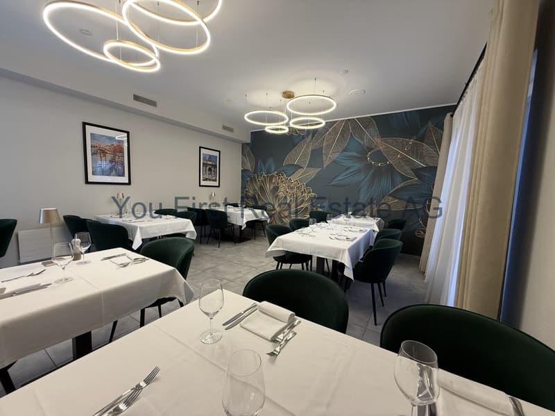 Exklusiver Restaurantbereich mit Designer-Pendelleuchten und raumhoher Wandgestaltung