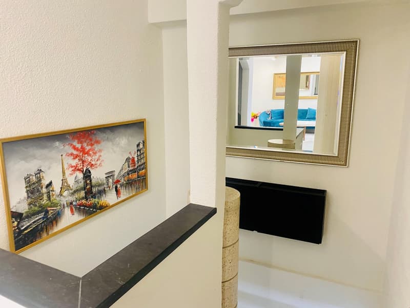 Wall painting, mirror, white walls, large staircase, black vent