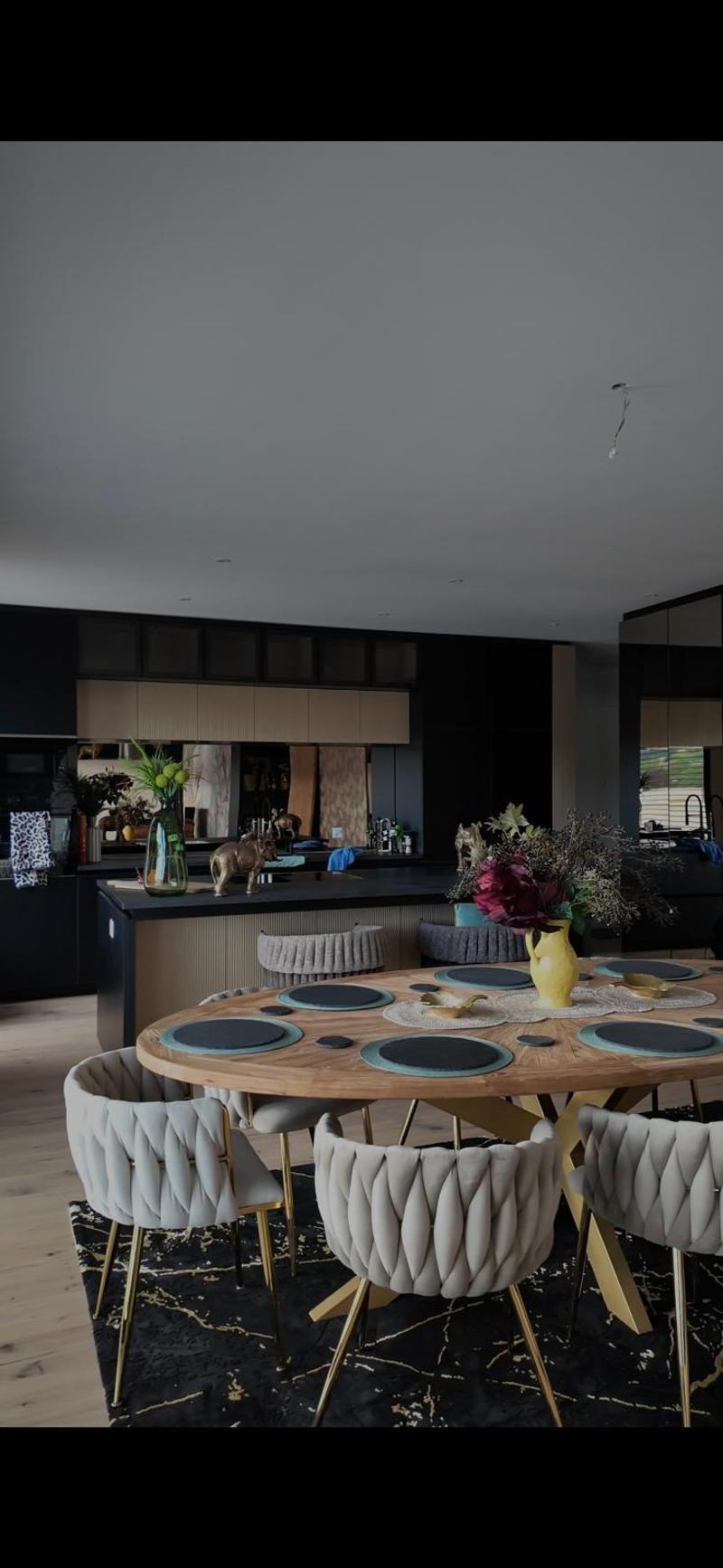 Modern kitchen with island, dining table, and plush chairs