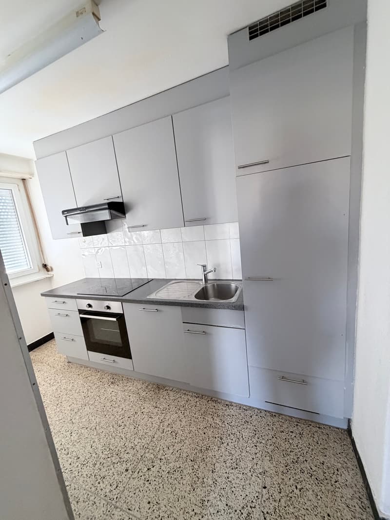 modern kitchen with white cabinets, granite countertop, stainless steel sink, oven, dishwasher, and a window
