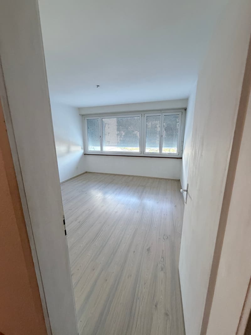 empty room, wooden floor, white walls, large window with blinds