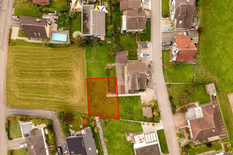 Red-outlined plot ready for building a new house with a pool