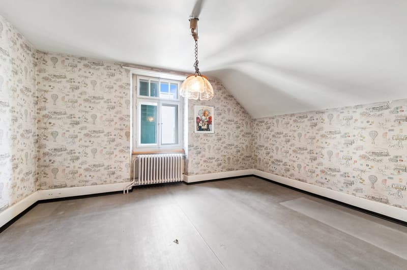 empty attic room with wallpaper, radiator, single glass window, ceiling lamp