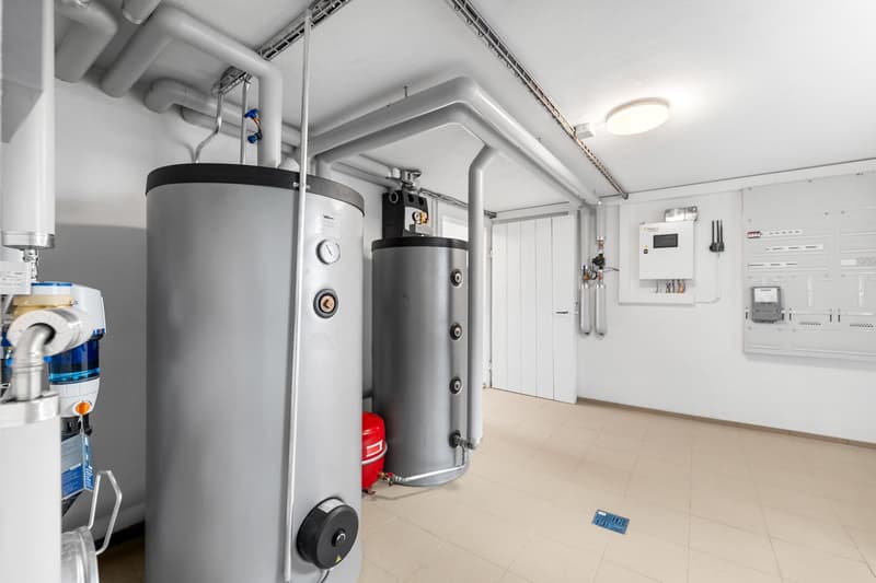 Utility room with water heaters, pipes, and electrical panels
