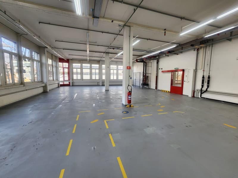 empty parking garage, white walls, windows, fire extinguishers, concrete floor, metal pipework