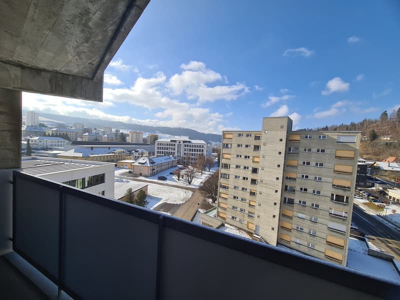 balcony with railing, view of city and mountains, snow on ground