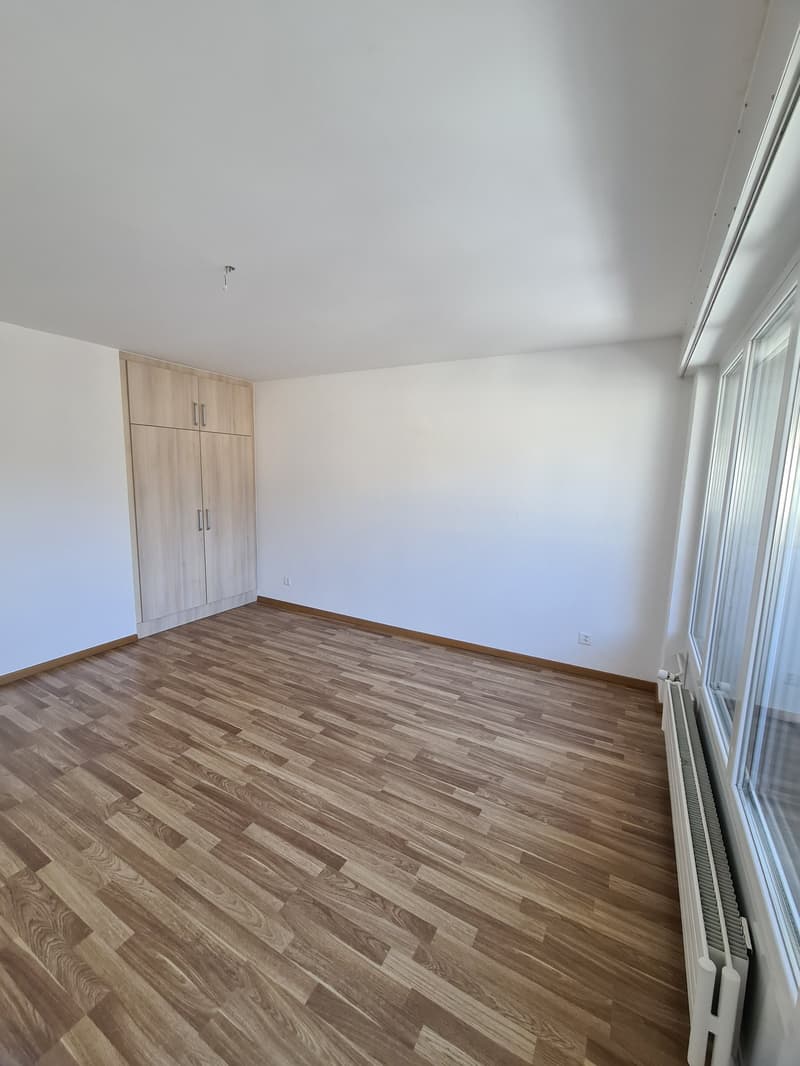 empty room, wooden floor, white walls, large windows, built-in wardrobe, radiator