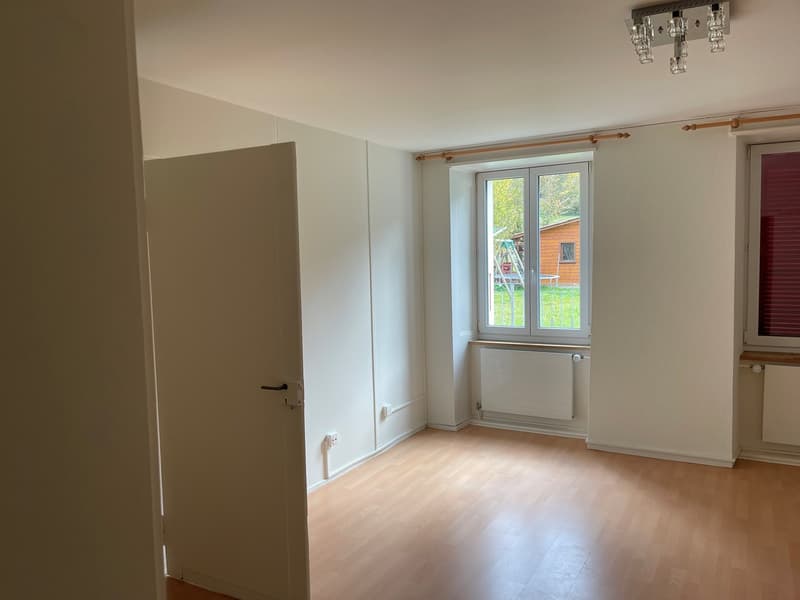 empty room with white walls, wooden floor, double window, heater on wall, open door