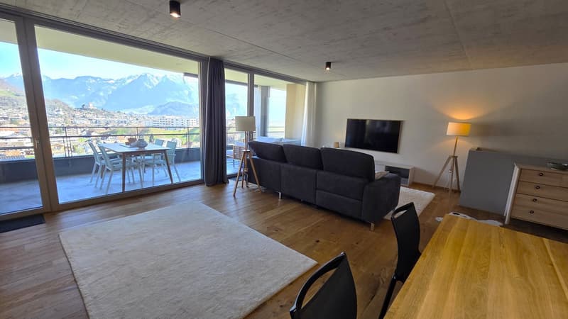 modern living room with large windows, balcony, wooden floor, gray couch, dining table, TV, lamps, rug