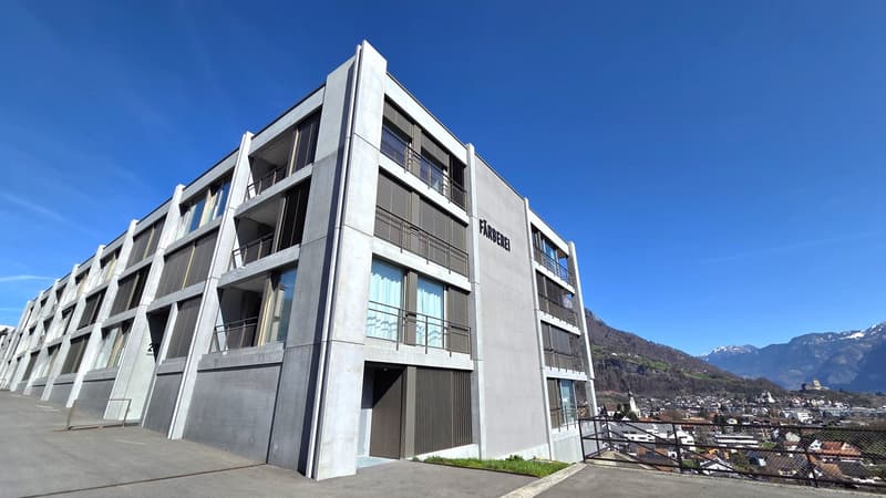 Modern apartment building, concrete exterior, multiple balconies, large windows, multiple floors