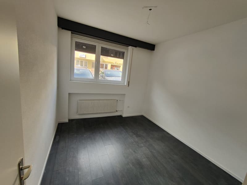 empty room, white walls, wooden floor, window, radiator