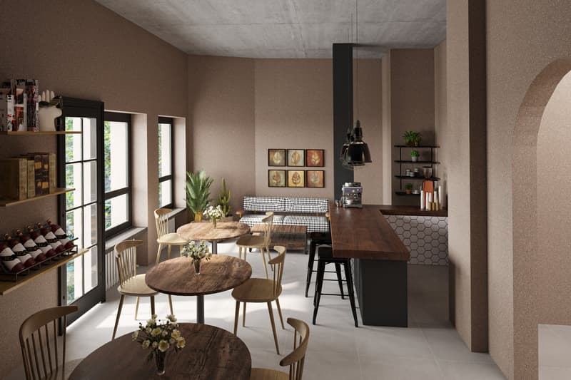 modern interior with wooden tables, chairs, shelves with books and wine bottles, a couch, a coffee machine, and a counter with a hexagon tile backsplash