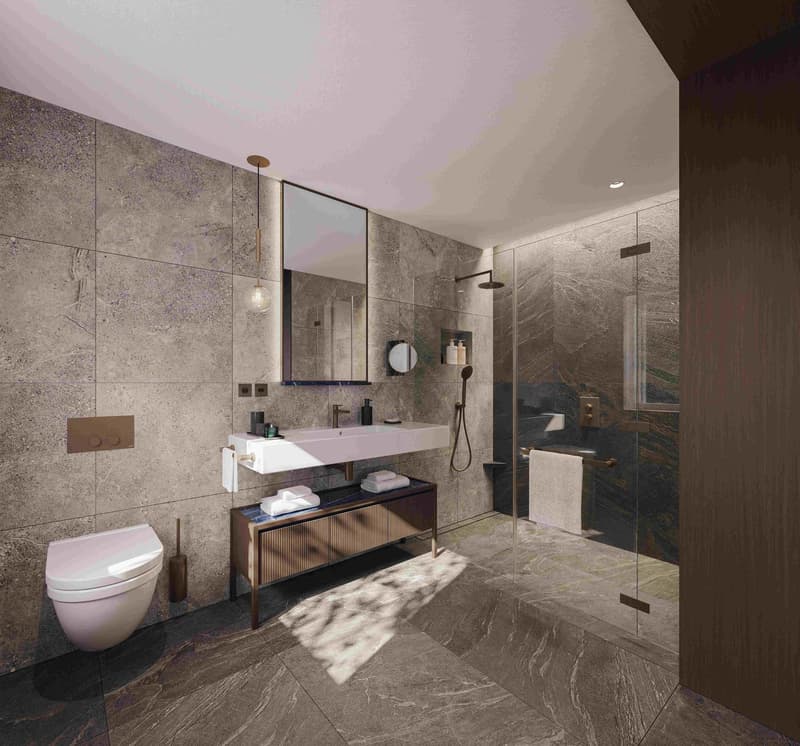 Large bathroom with gray marble tile walls and floors, a vanity with a sink and mirror, a toilet, and a glass-enclosed shower area.