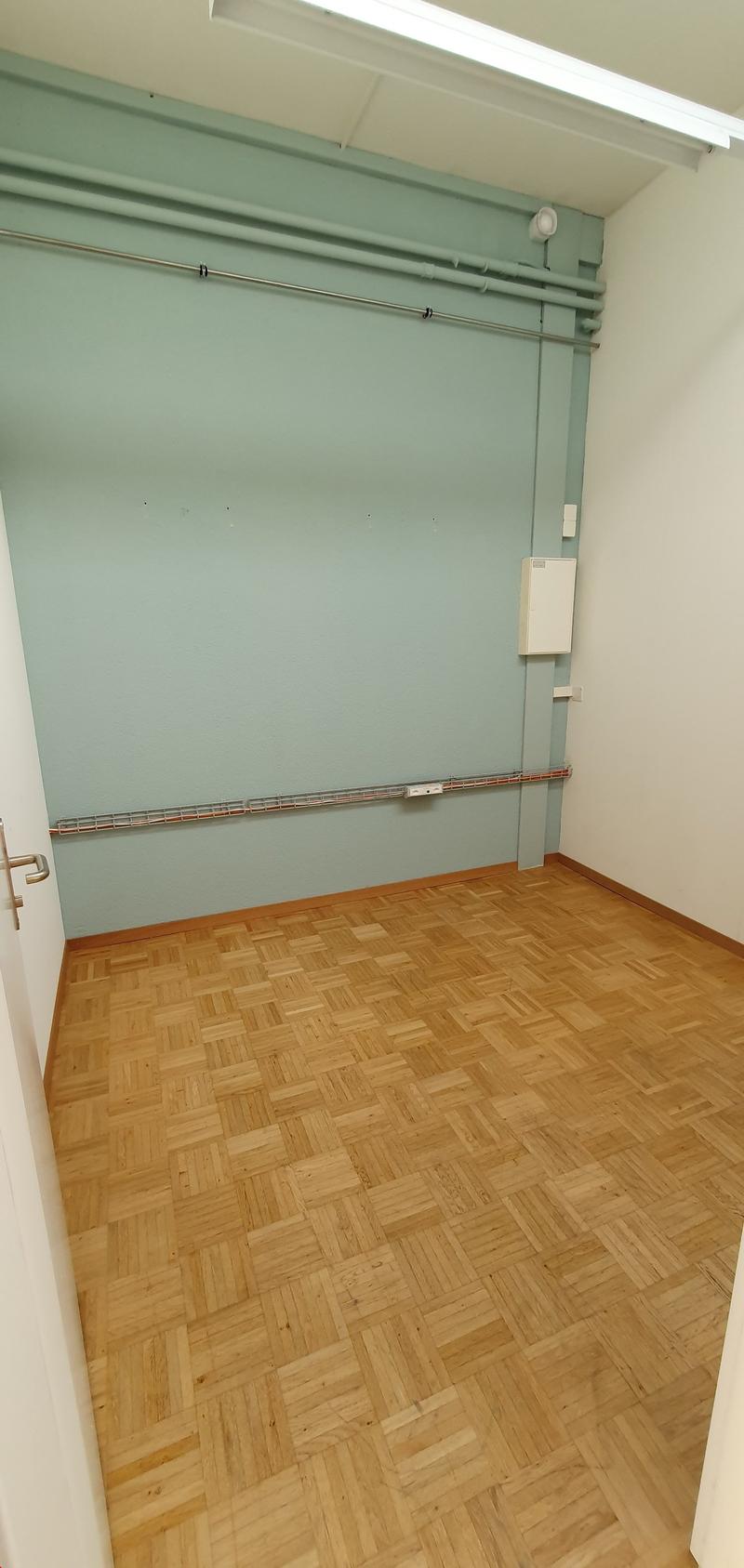 empty room, wooden floor, green wall, white ceiling, metal pipe, white door