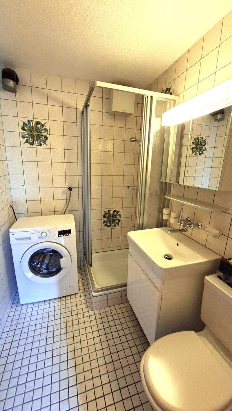 gepflegtes Badezimmer mit Dusche und Waschmaschine