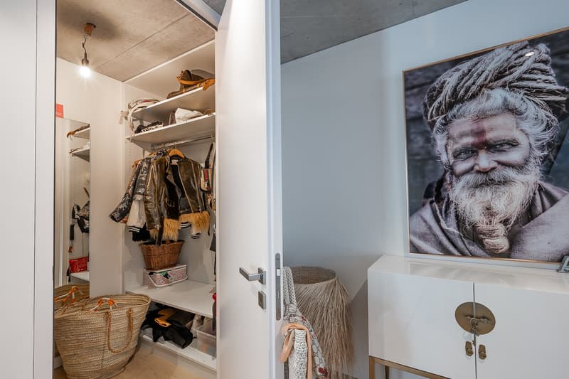 walk-in closet with shelves, hanging clothes, baskets, and a mirror